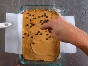 Spread the caramel evenly over the base, then place the container in the freezer for 3–4 hours to set.