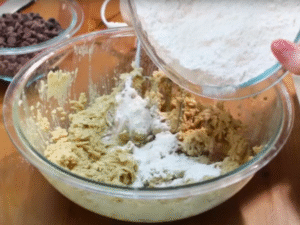Gradually add the dry ingredients to the wet mixture, stirring until just combined. Fold in plenty of chocolate chips.