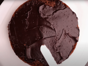 Coat the entire cake with ganache, smooth the surface, and refrigerate 4–6 hours (or overnight) to set.